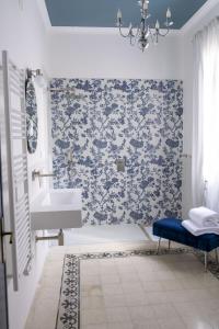 a bathroom with a sink and a blue floral wallpaper at Dimora delle Storie in Tempio Pausania