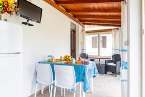 Un comedor con una mesa y sillas azules. en Casa Paola, en Tortolì