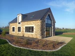 ein Steinhaus mit schwarzem Dach in der Unterkunft Maison Beniguet 6 places proche Paimpol et Tréguier in Pleumeur-Gautier