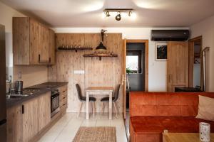a kitchen with wooden cabinets and a table and chairs at Dunakavics vendégház stranddal in Zebegény