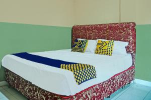 a bed with colorful pillows on top of it at Hotel O Romli in Rumpuktulunghoni