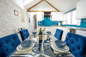comedor con mesa de cristal y sillas azules en Beautiful Quayside Cottage Looe, en Looe 15 fotos más