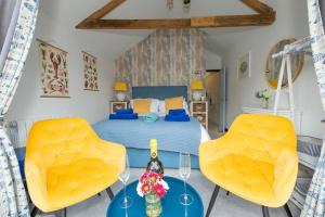 1 dormitorio con 1 cama y 2 sillas amarillas en Beautiful Quayside Cottage Looe, en Looe