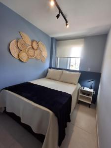a bedroom with a bed with a blue wall at Flat Coqueiros 101 Praia in Tamandaré