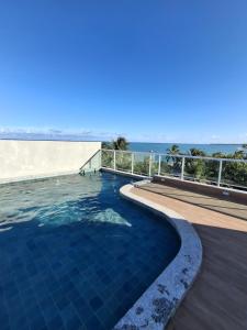 a swimming pool with a view of the ocean at Flat Coqueiros 101 Praia in Tamandaré