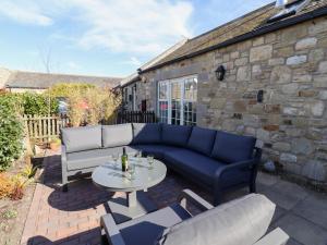 シーハウシズにあるLittle Ternの青いソファとテーブル付きのパティオ