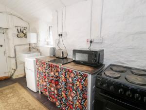 a kitchen with a microwave and a stove at Nyth Yr Eryr in Blaenau-Ffestiniog