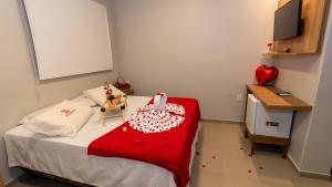 a small bedroom with a bed with a red blanket at Hotel Marajó - Turismo de Experiência in Soure