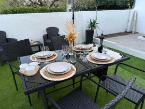 a black table with plates and glasses and a bottle of wine at Casa Santos in Sardoal