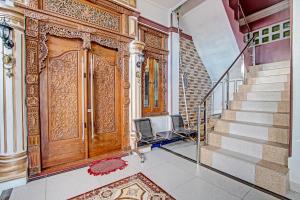 an entrance to a building with a wooden door at Hotel O Amole Homestay Syariah in Cilacap