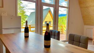 two bottles of wine on a wooden table in a kitchen at Cricova House in Colibiţa +7 photos