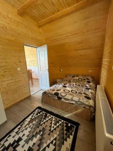 a bedroom with a bed in a log cabin at Cricova House in Colibiţa