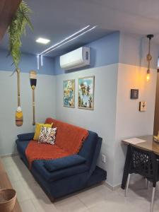 a room with a blue couch in a room at Flat Coqueiros 101 Praia in Tamandaré