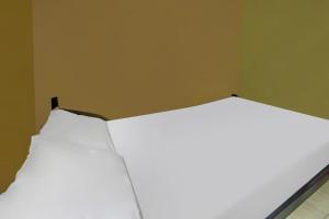 two beds in a corner of a room at OYO 92308 Kos Duduk in Lajor