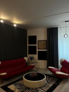 - un salon avec un canapé rouge et une cheminée dans l'établissement Apartmán u parku Parukářka, à Prague