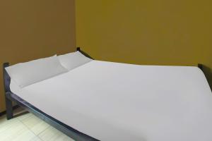 a large white bed in a room at OYO 92308 Kos Duduk in Lajor +17 photos