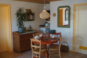 a kitchen with a table with chairs and a mirror at La petite source in Florenville