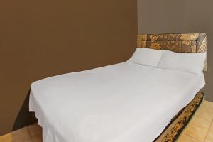 a large bed with white sheets and pillows at OYO 92308 Kos Duduk in Lajor