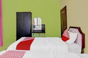a bedroom with a bed with white and red pillows at Hotel O Rindu Sempadan Cottage Near Taman Wisata Rindu Sempadan in Pekanbaru +19 photos