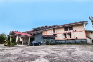 un edificio con un coche aparcado delante en Hotel O Rindu Sempadan Near Taman Wisata Rindu Sempadan, en Pekanbaru