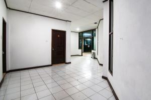 Un pasillo vacío con una puerta y un suelo de baldosas. en Hotel O Rindu Sempadan Near Taman Wisata Rindu Sempadan, en Pekanbaru
