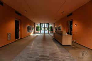 an office hallway with orange walls and a reception desk at Luxury by the Sea - Free Park - Gym - UltraWiFi in Genova +28 photos