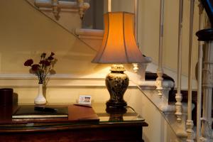 a lamp sitting on top of a table next to a vase at The Ben Doran Guest House in Edinburgh