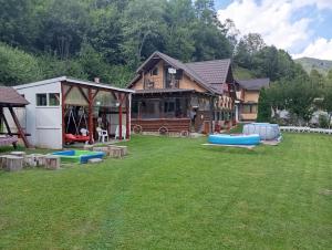 ein Haus mit einem Hof mit mehreren aufblasbaren Konflikten in der Unterkunft Casa Rania si Ayan Sătic Rucăr in Ciocanu