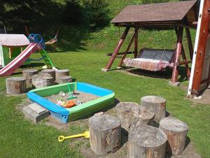 einem Sandkasten mit einem Spielset und einer Rutsche in der Unterkunft Casa Rania si Ayan Sătic Rucăr in Ciocanu