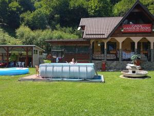 Eine Frau, die in einem Pool im Garten sitzt. in der Unterkunft Casa Rania si Ayan Sătic Rucăr in Ciocanu + 38 Fotos