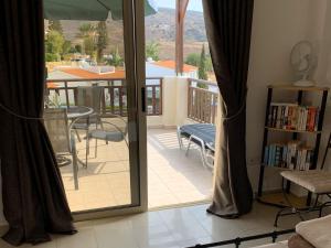 a room with a door open to a balcony with a table and chairs at Park View Gardens H502 in Peyia