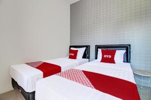 two beds sitting next to each other in a room at Collection O 92363 Kp Inn in Yogyakarta