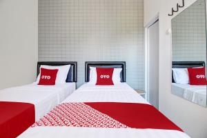 two beds with red pillows in a room at Collection O 92363 Kp Inn in Yogyakarta +27 photos