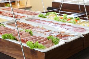 a display case filled with different types of meat at HOTEL PARQÉO im A66 in Gelnhausen