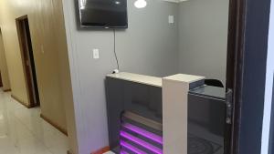 a desk in a room with a tv on a wall at Spring forth guest house in De Grendel