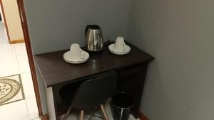 a table with two plates and a coffee maker on it at Spring forth guest house in De Grendel