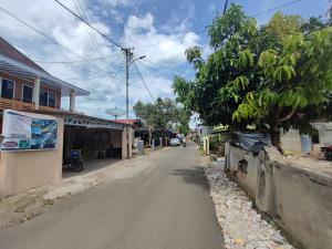 una calle vacía en un pueblo con un árbol en OYO 92357 Zzip Homestay, en Pagaralam