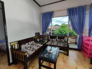 una sala de estar con un sofá y una mesa en OYO 92357 Zzip Homestay, en Pagaralam