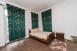 a bedroom with green walls with a bed and a table at Hotel Emir in Strehaia