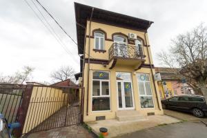 a yellow house with a balcony and a fence at Hotel Emir in Strehaia