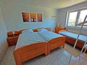 a bedroom with a large wooden bed and a window at gemütliche Ferienwohnung in ruhiger Lage, Nähe Luxemburg und Trier - Holiday and Nature Olk in Ralingen