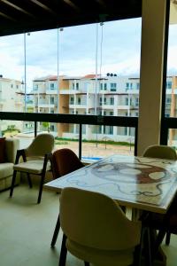 カボ・ネグロにあるAppartement haut standing mirador golf 3の大きな窓のある部屋にあるテーブルと椅子