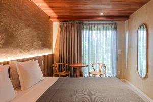 une chambre avec un lit, une table et une fenêtre dans l'établissement Vila Sal Boutique Noronha, à Fernando de Noronha 25 autres photos