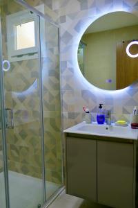 カボ・ネグロにあるAppartement haut standing mirador golf 3の洗面台と鏡付きシャワーを備えたバスルーム