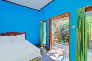 a bedroom with a bed and a sliding glass door at Hotel O Mustika in Mendaya