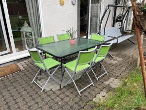 a table with green chairs and a potted plant on it at Dhünn lake holiday house in Kürten