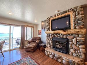 ein Wohnzimmer mit einem Steinkamin und einem Flachbildfernseher in der Unterkunft Lake View Condo 874 4 with Awesome Lake View in Garden City