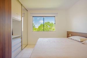 a bedroom with a bed and a window at GB120 Ótimo Apartamento com 3 Suítes - Guarajuba in Monte Gordo +27 photos