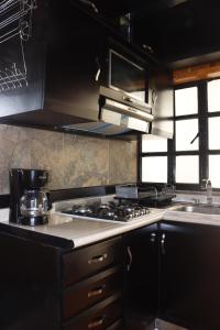 una cocina con estufa y fregadero en El Balcón del Aventurero, en San Cristóbal de Las Casas