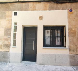 un edificio con una puerta negra y una ventana en Estudio El Santo 1, en Salamanca